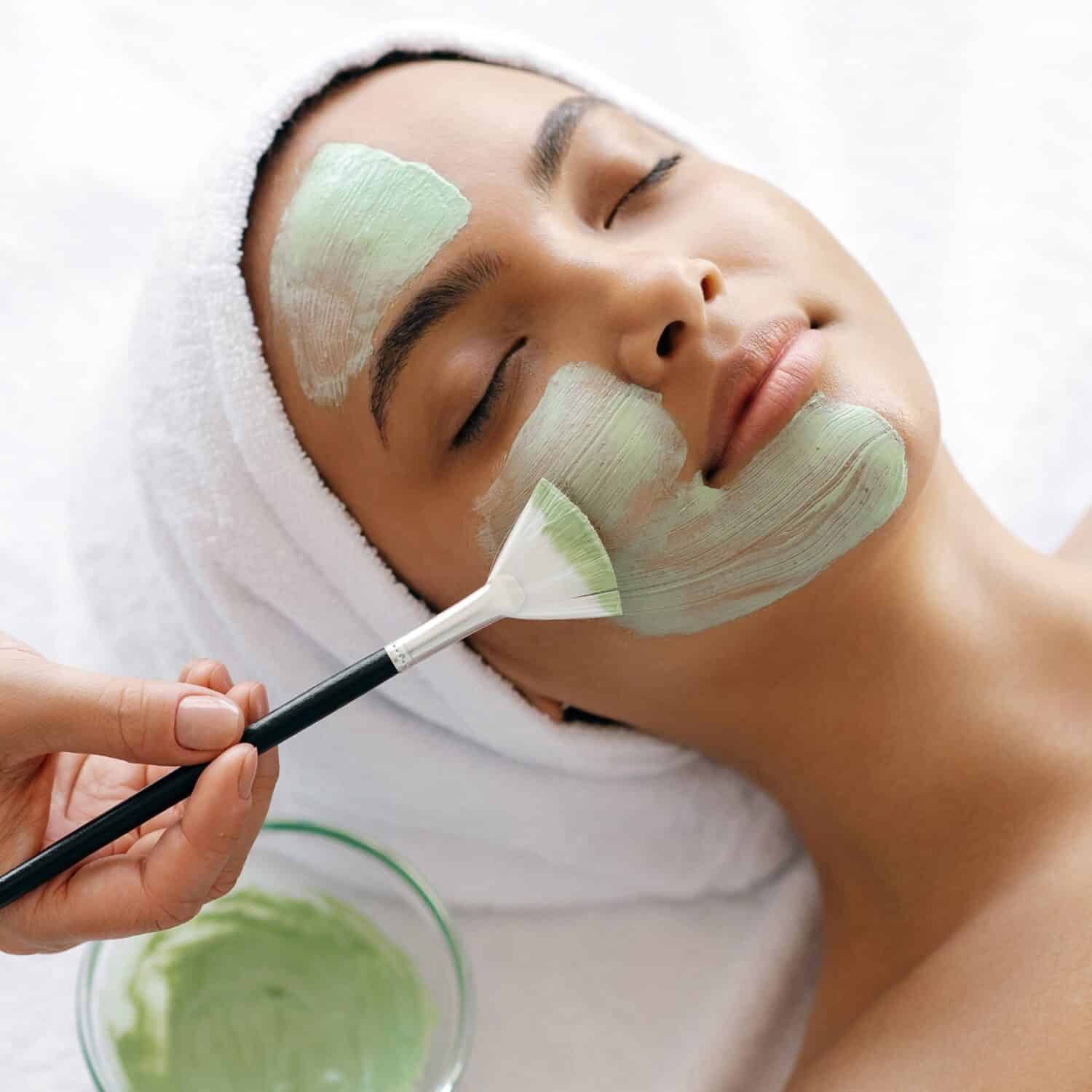 Enjoying a relaxing facial treatment with soothing green cream applied.