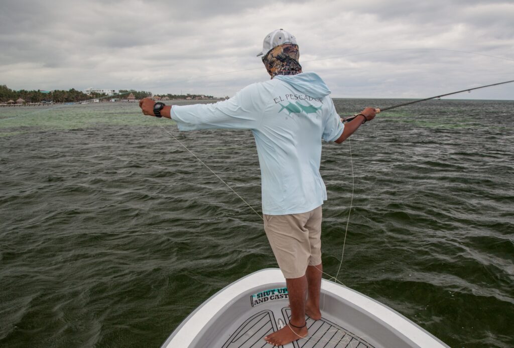 Angler enjoying a fishing adventure on the open water under a cloudy sky.