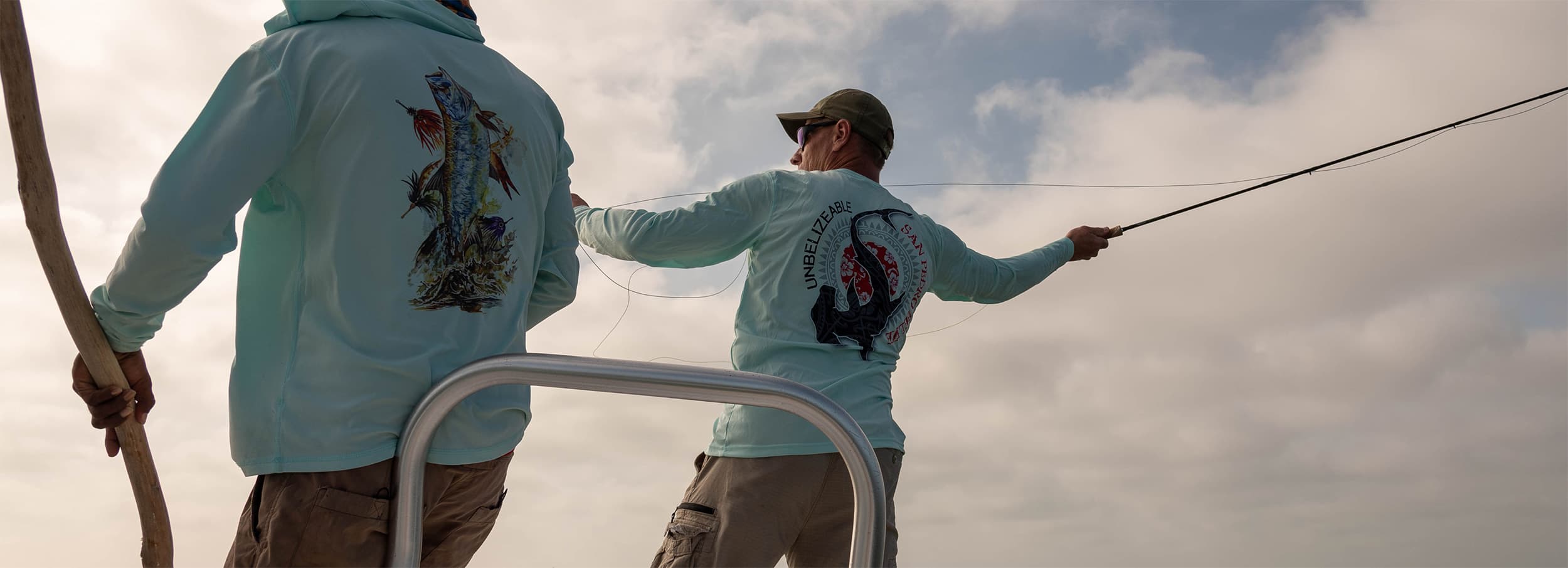 Two friends enjoying a fishing adventure on a boat under a cloudy sky.