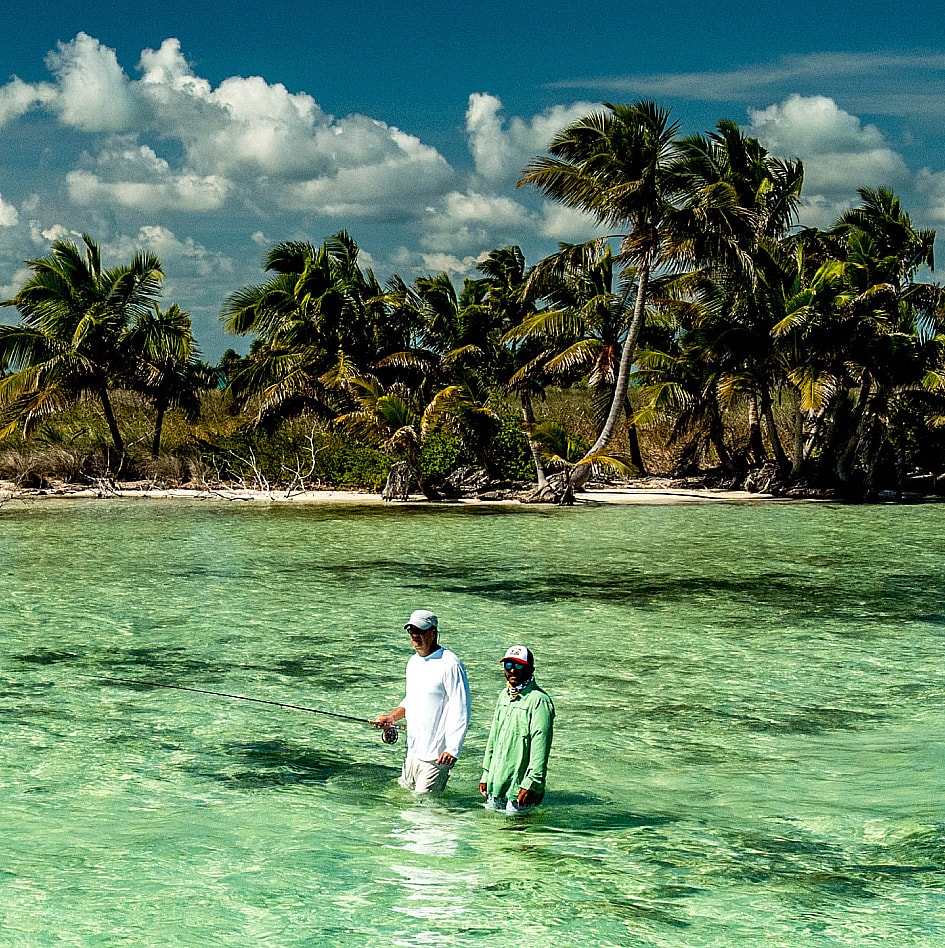 Two fishermen enjoying a peaceful day in crystal-clear tropical waters.