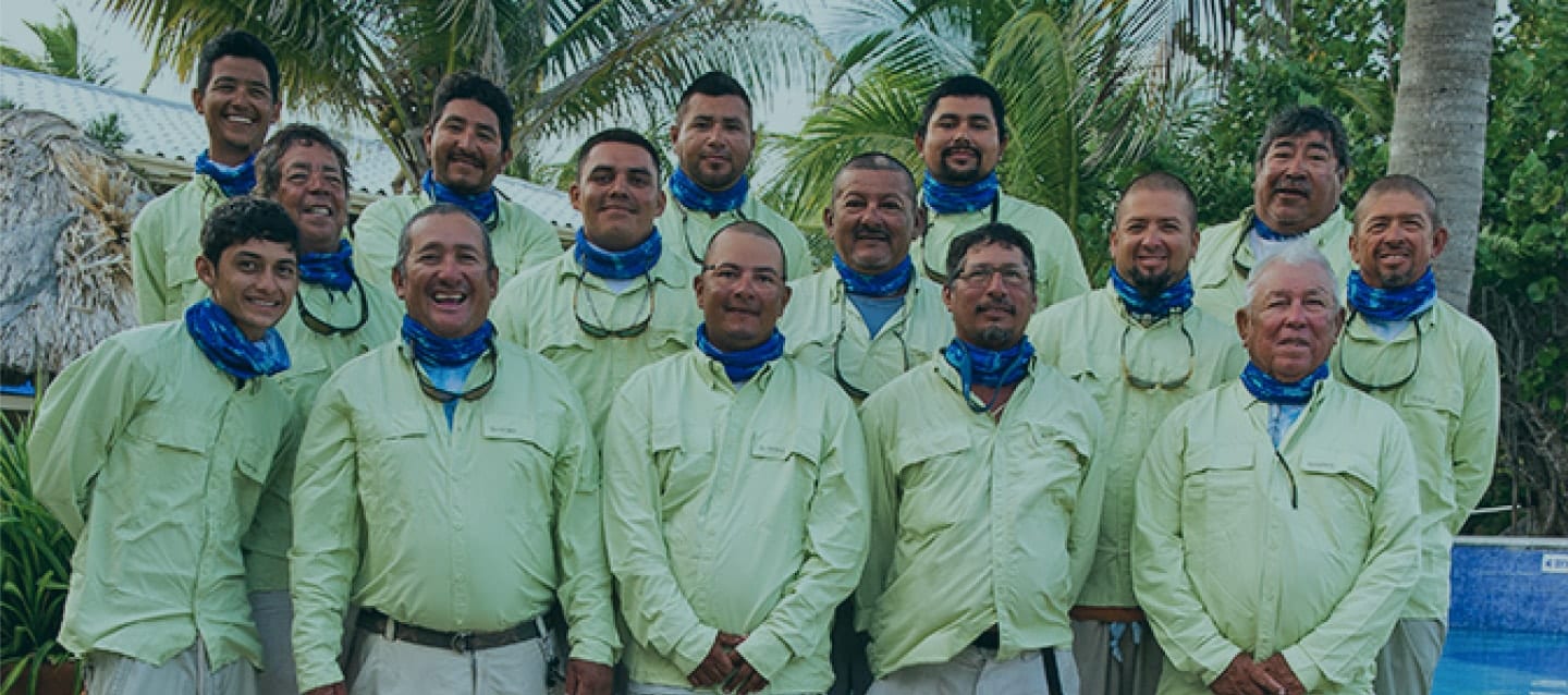 Group of friends celebrating together in matching outfits by the beach.