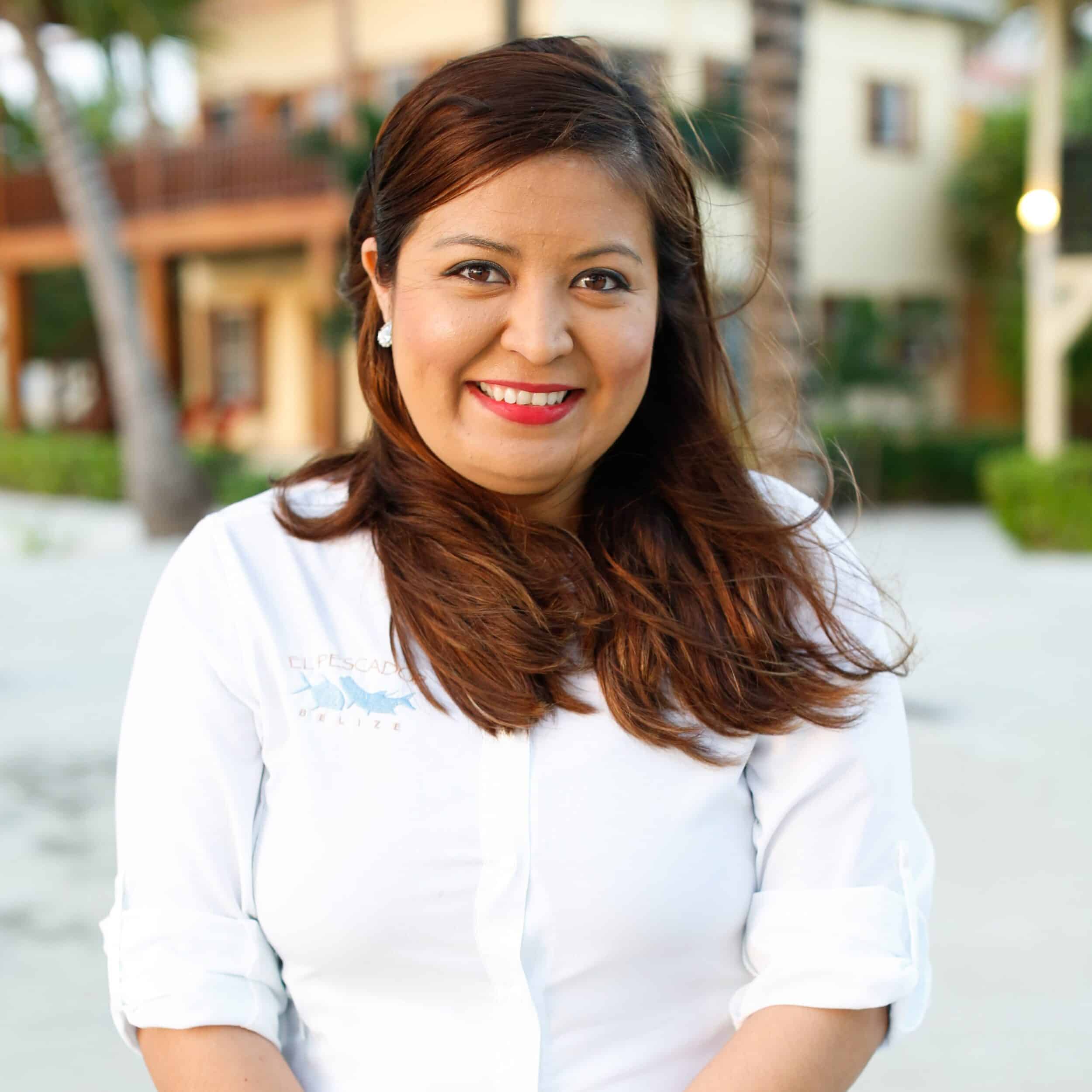 El Pescador team member smiles in a tropical outdoor setting.