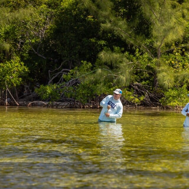 http://Anglers%20enjoying%20a%20peaceful%20day%20of%20fishing%20in%20calm,%20clear%20waters%20surrounded%20by%20greenery.