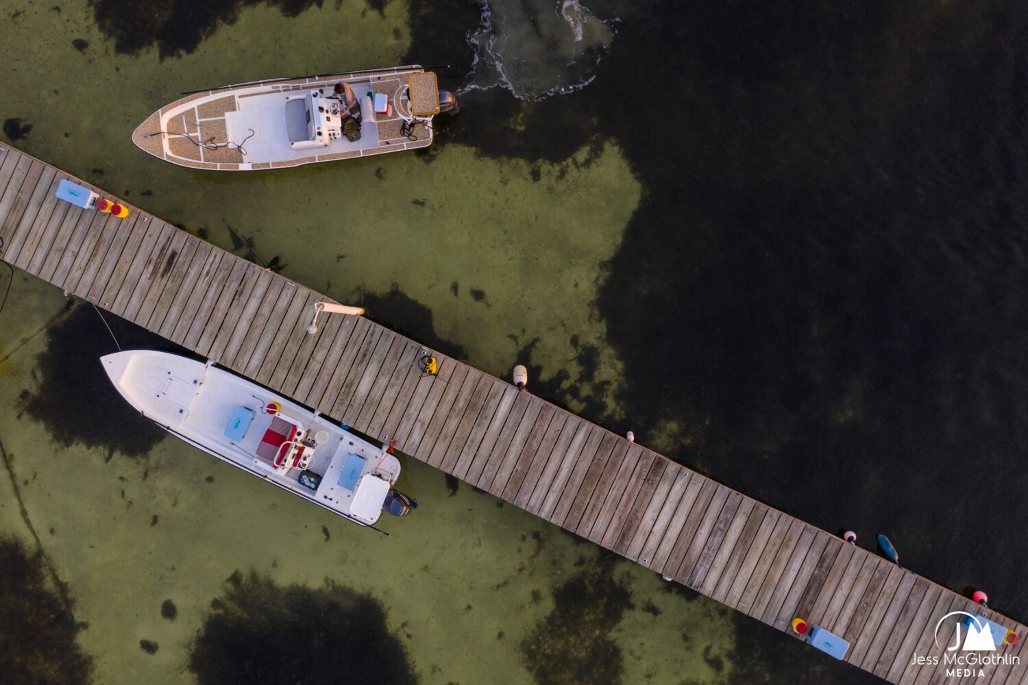 Boats docked peacefully on calm waters with a wooden pier.