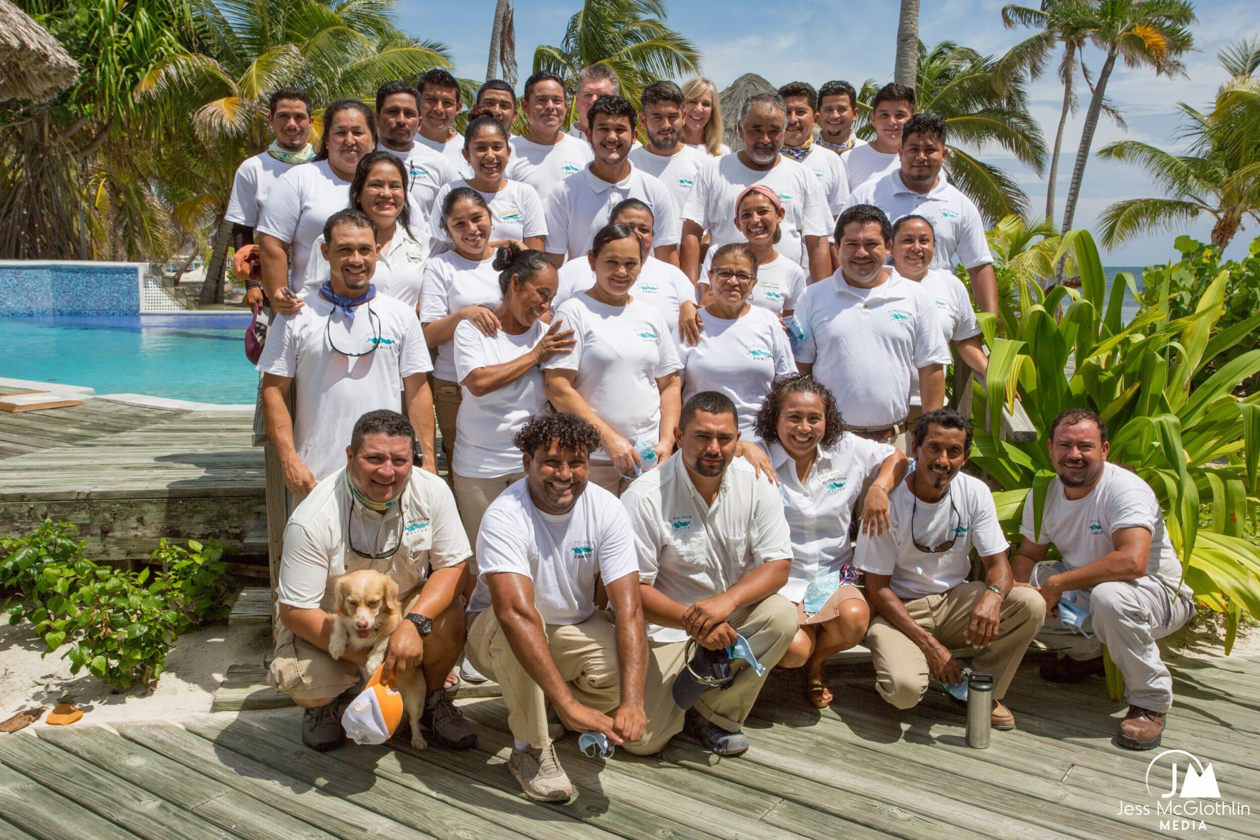 Team gathering by the pool in a tropical paradise setting.