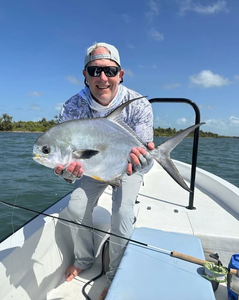 Successful angler proudly displays a beautiful fish on a sunny day.