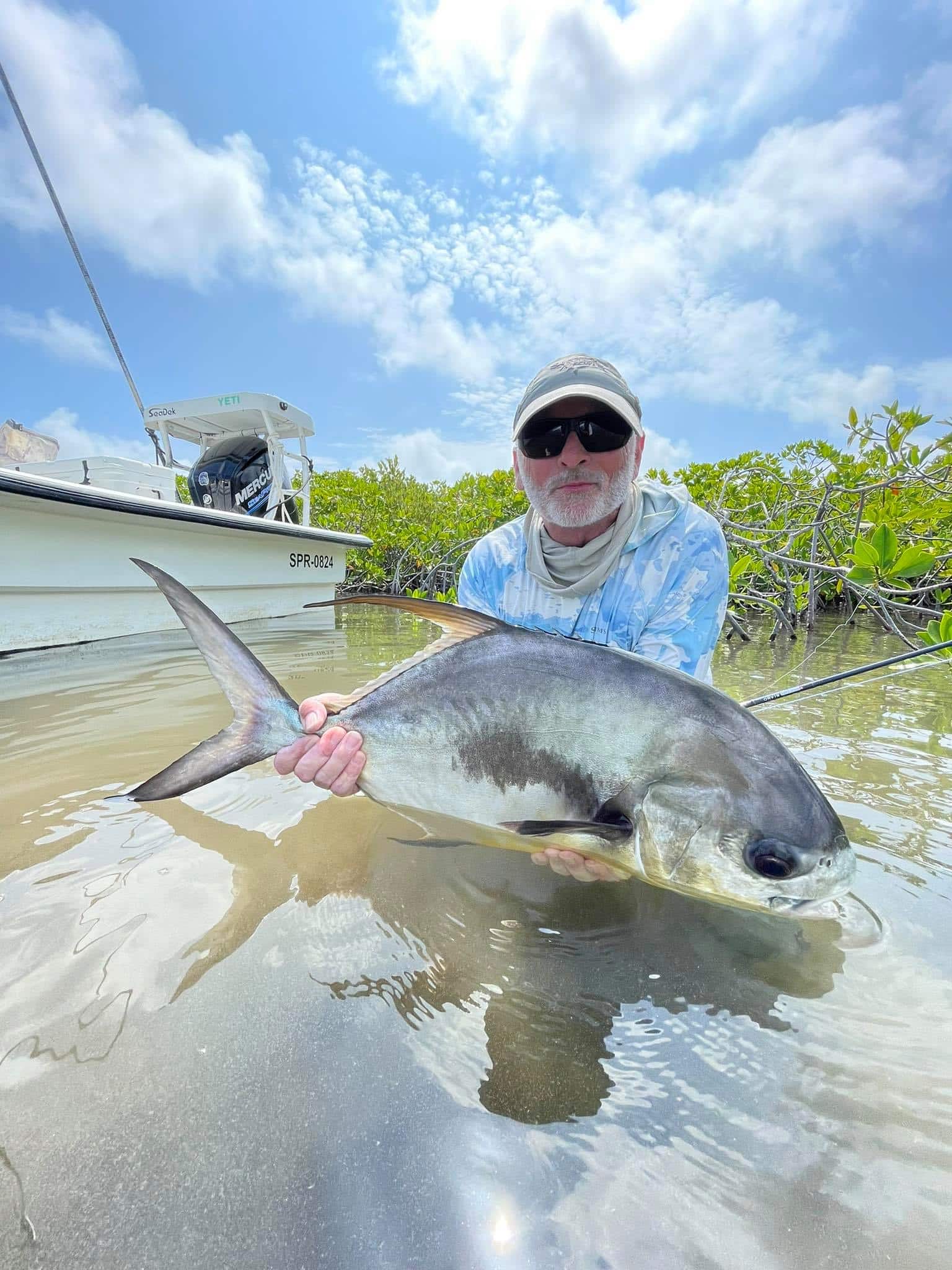 Angler proudly displays a stunning catch on a sunny fishing adventure.
