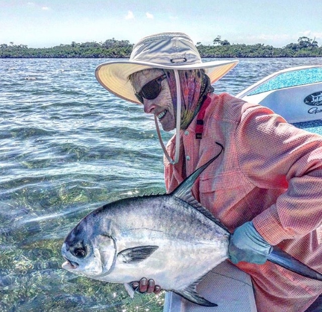 Woman with a large permit fish, enjoying a sunny day of fishing.