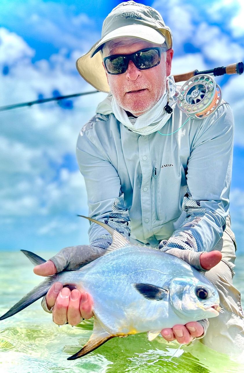 Angler proudly displays a stunning catch against a picturesque sky.
