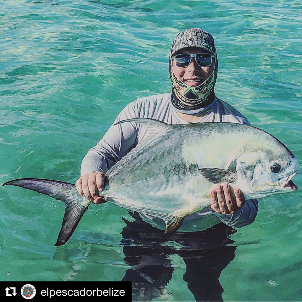 Angler shows off a stunning permit fish in Belizes crystal-clear waters.