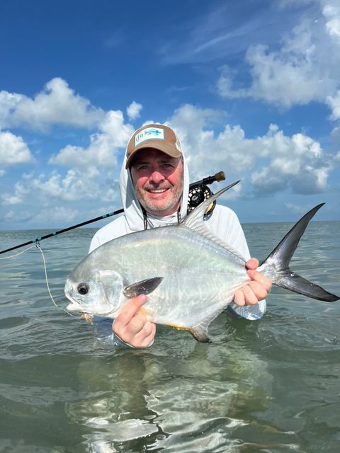 Angler proudly holds a beautiful fish caught in clear waters.