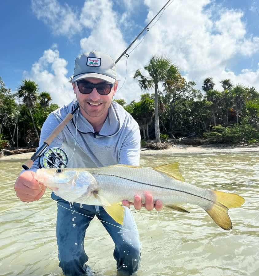 Snook fishing adventure in sunny Florida, showcasing a proud angler with a catch.