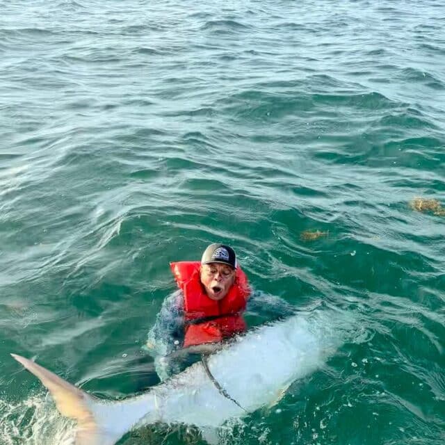 Angler proudly holds a massive fish during an exciting fishing adventure.