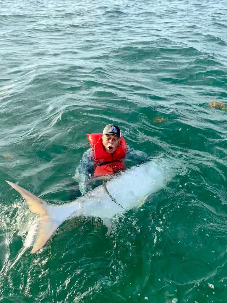 Angler proudly holds a massive fish during an exciting fishing adventure.