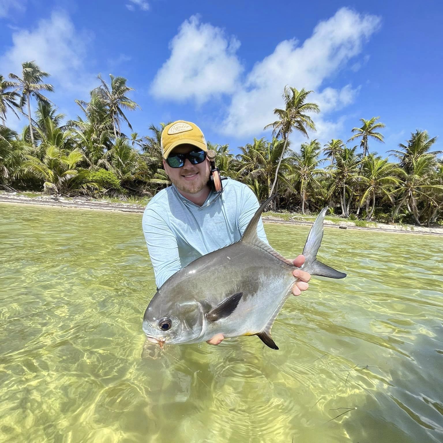 Angler enjoying a successful catch in a beautiful tropical setting.