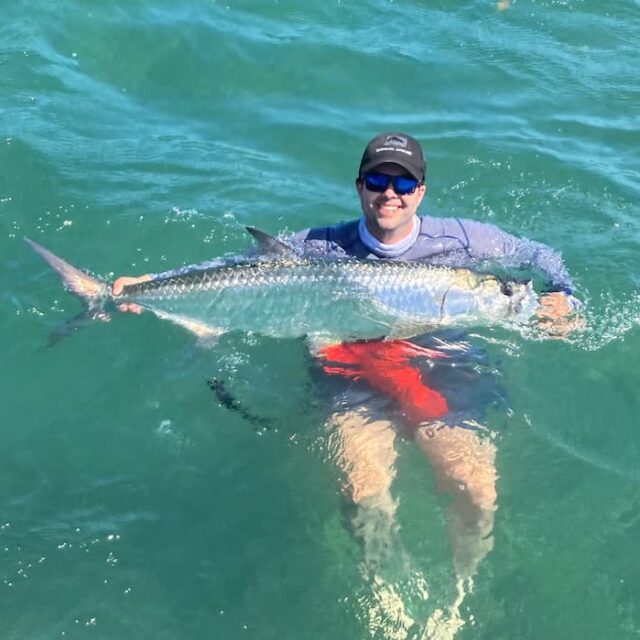Man Holding Large Fish in Water