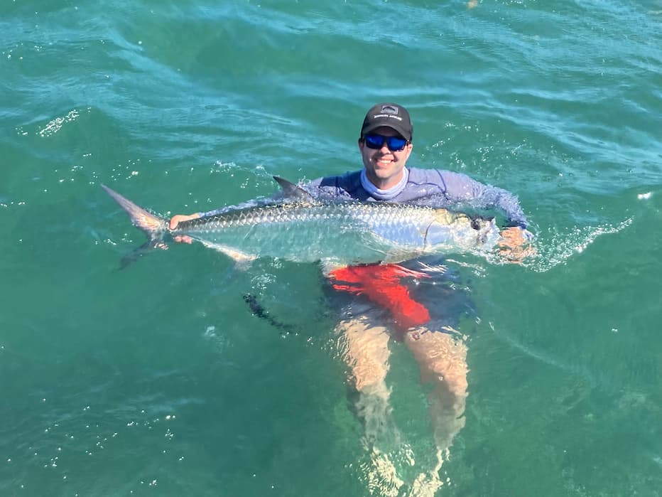 Man Holding Large Fish in Water