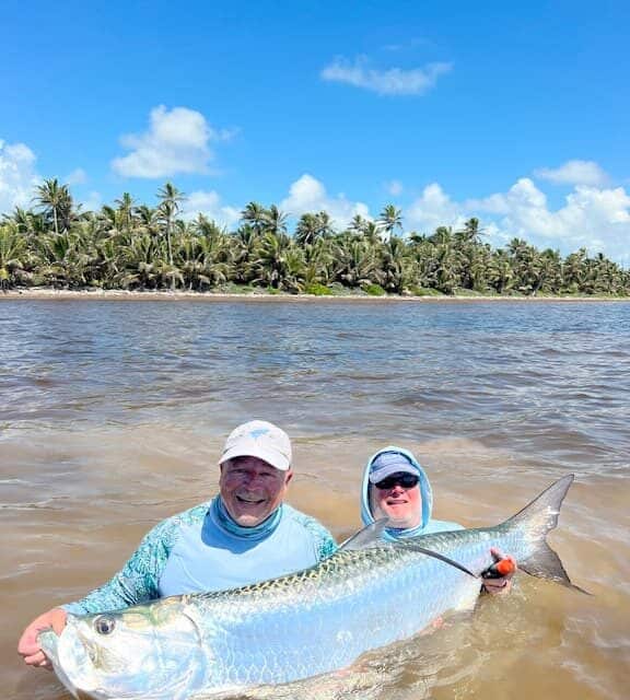 Thrilling tarpon catch during a tropical fishing adventure.