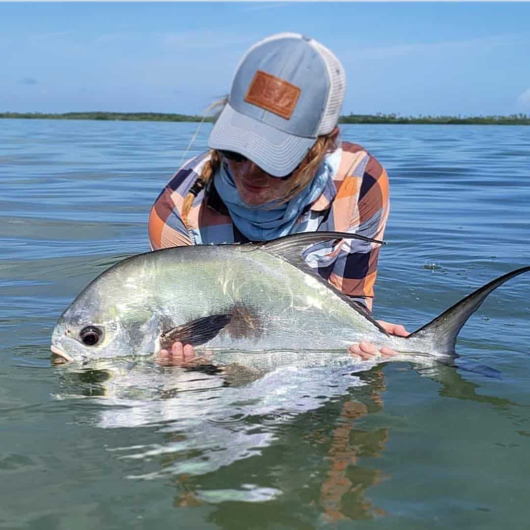 Angler proudly displays a stunning fish catch in tranquil waters.