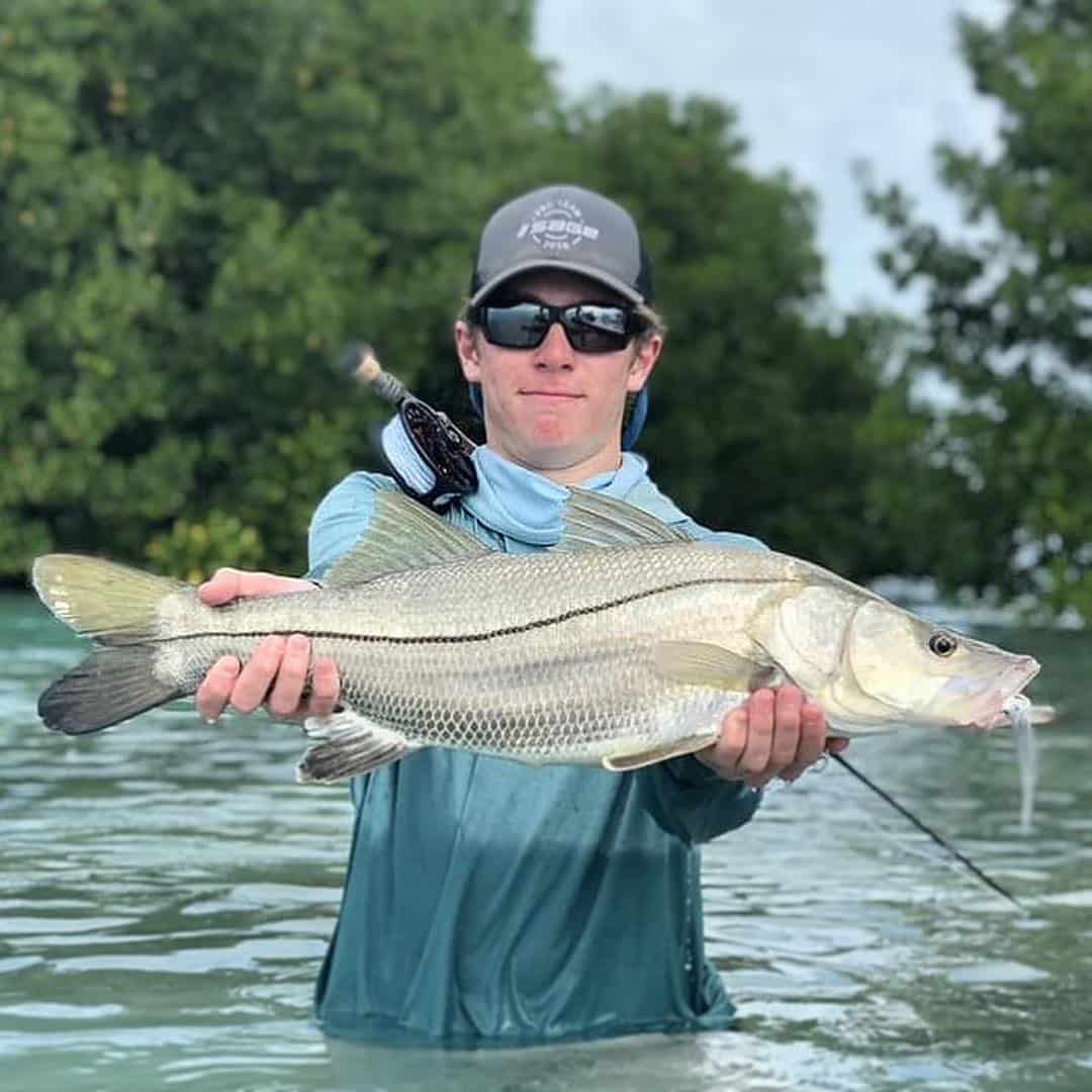 Angler holds a significant catch during an exciting Belize fishing experience.
