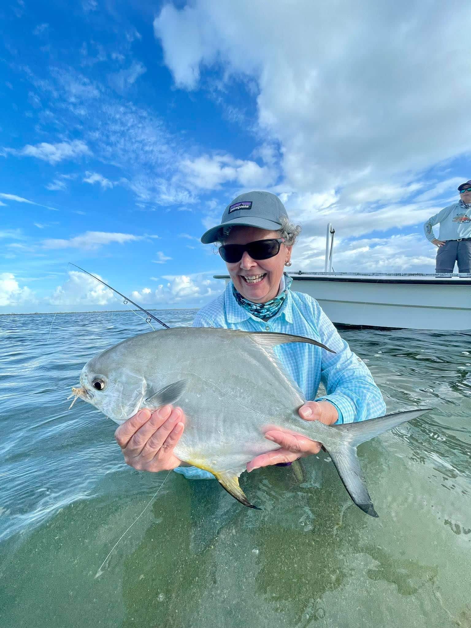 Happy angler proudly holding a fish on a sunny day at sea.