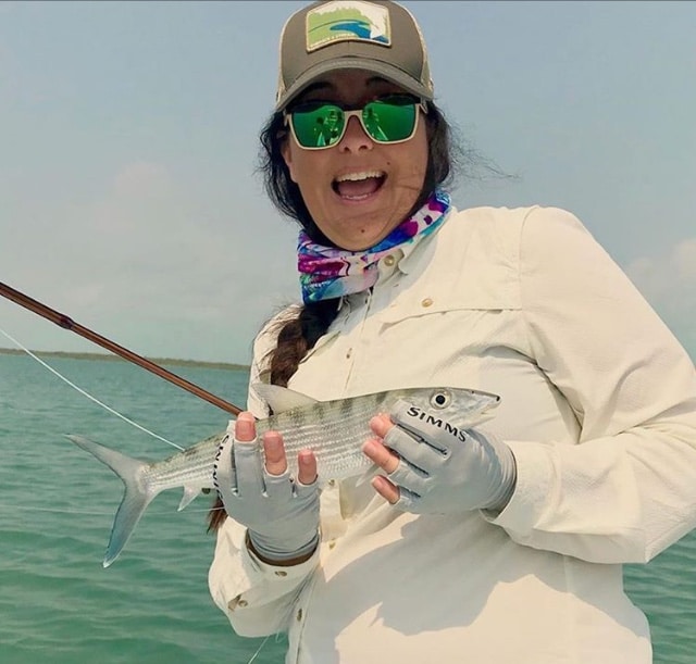 Excited angler holds a fish, celebrating a successful day on the water.