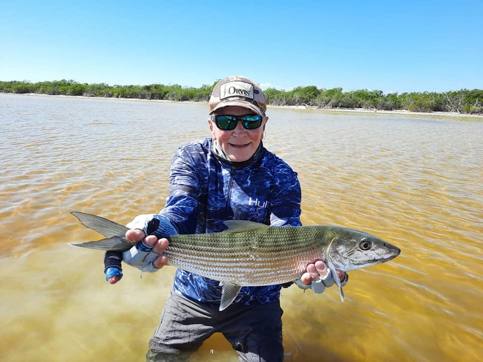 Proud angler holding a stunning fish against a beautiful natural backdrop.