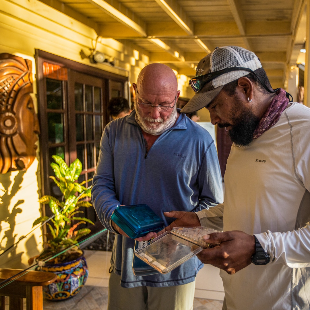 Men examining new outdoor gear for fishing and adventure planning.