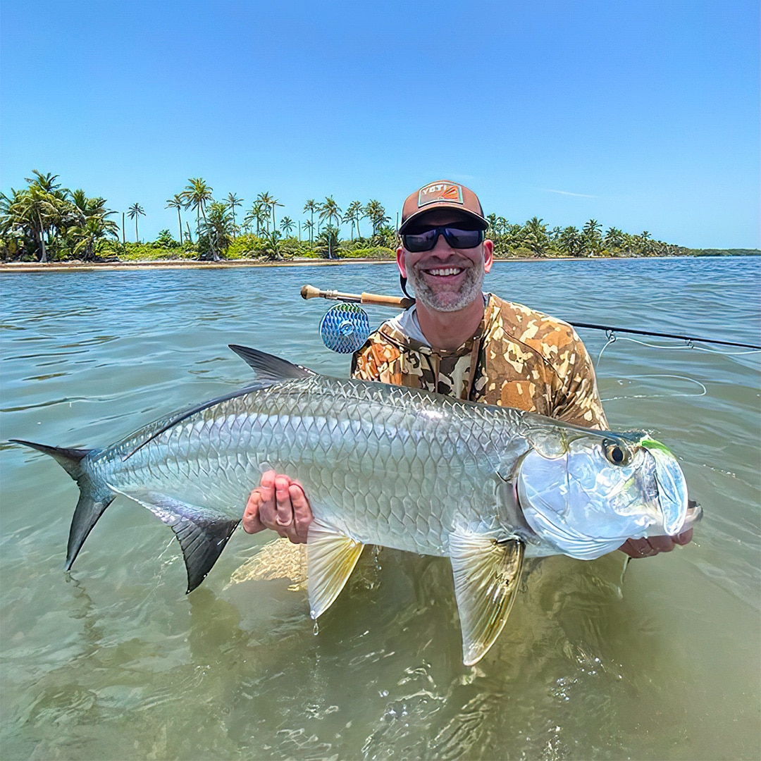 Angler celebrates a successful catch of a large fish in tropical waters.