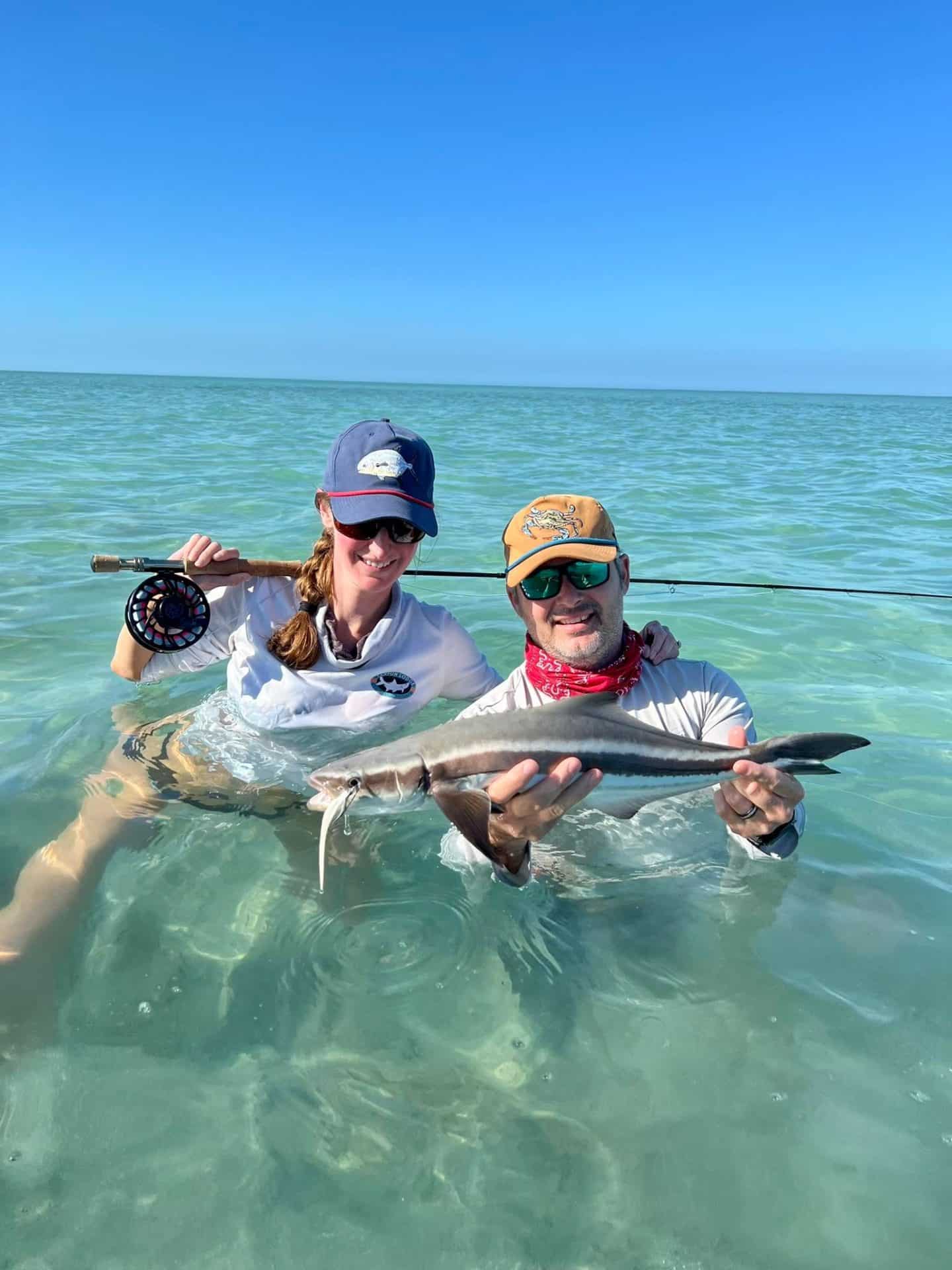 Fishing fun: Friends celebrate their catch in beautiful shallow waters.