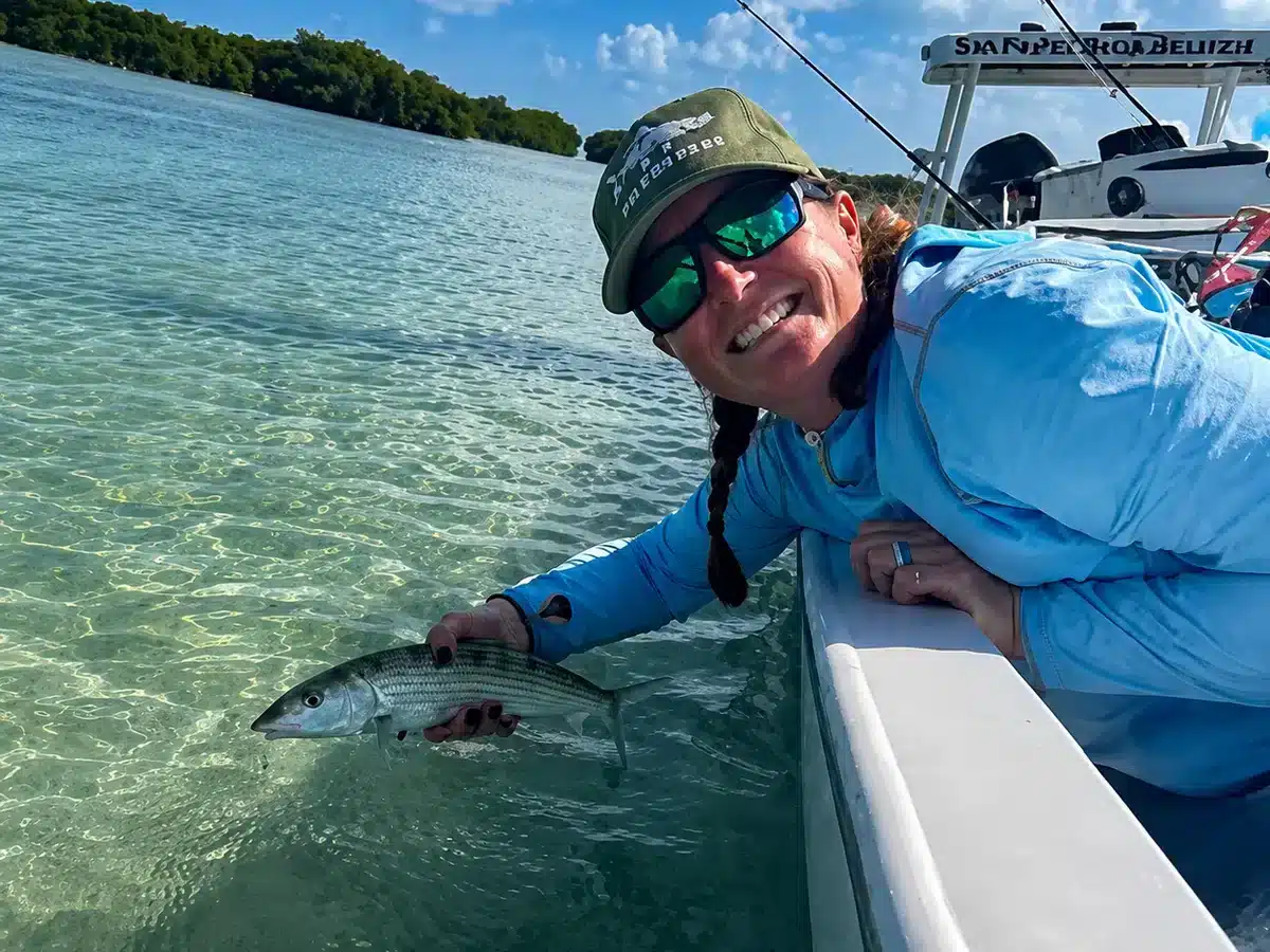 Megan Nellen releasing a bonefish beside a skiff