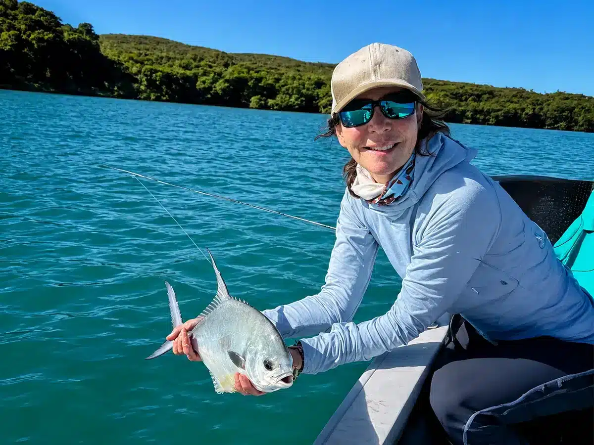 Whitney Gould holding a permit while fishing in Belize